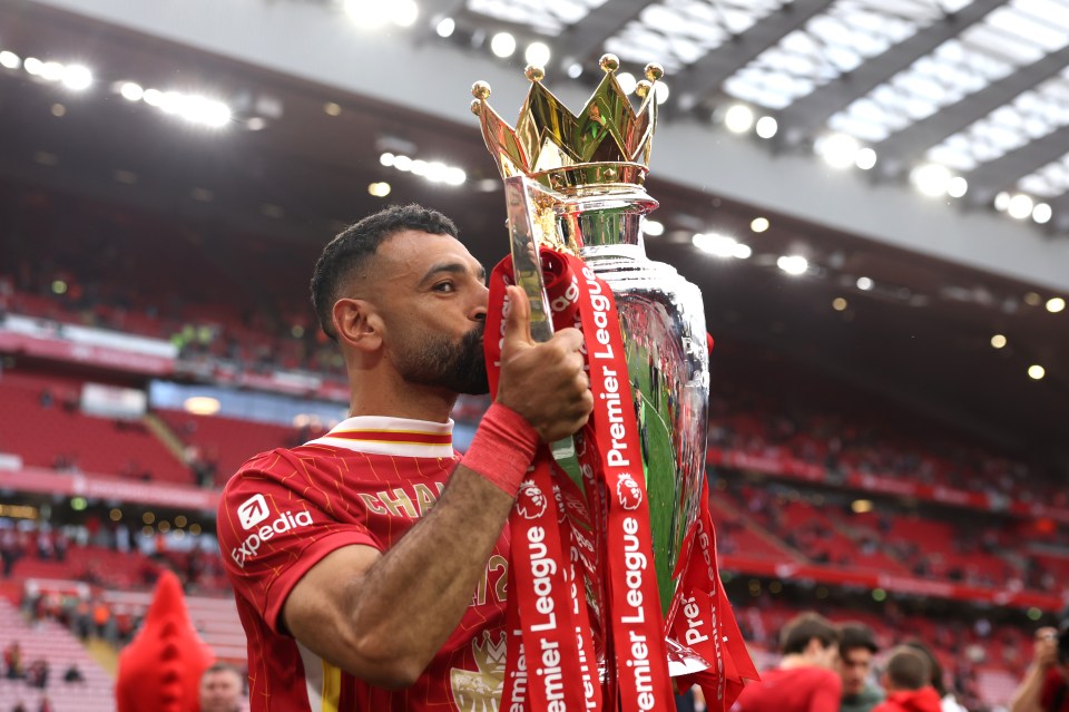 Mohamed Salah kissing the Premier League trophy.