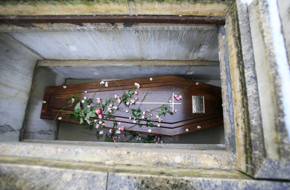 Coffin with roses in a grave.