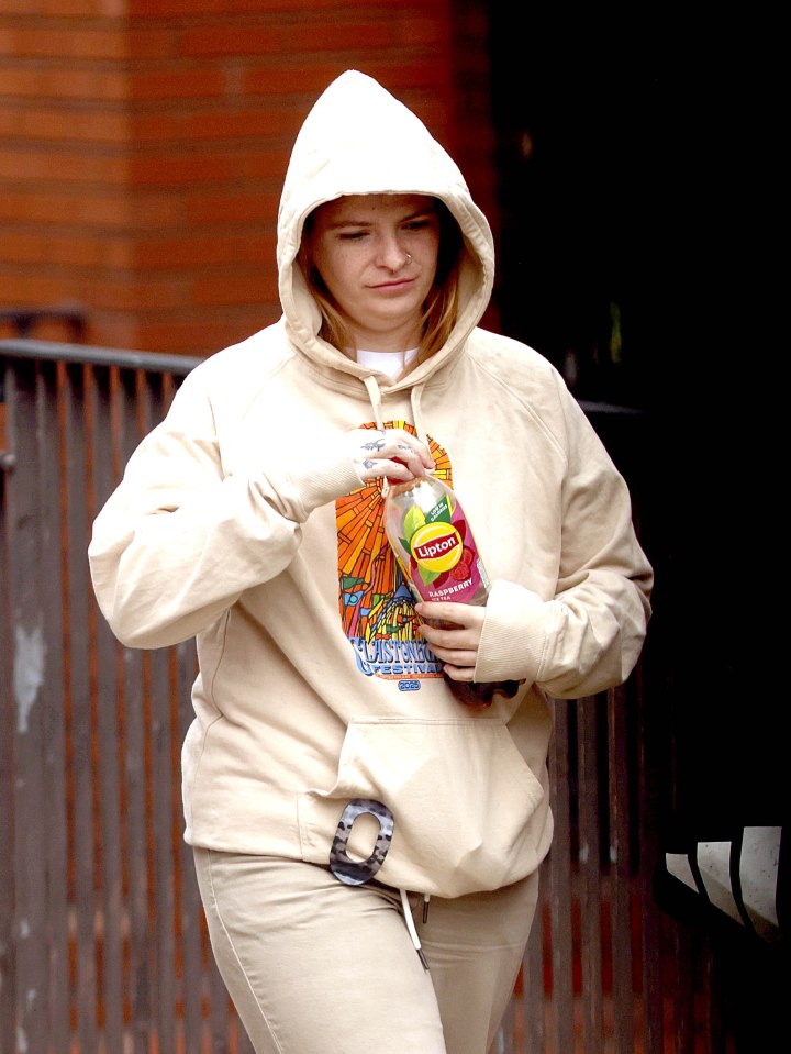 Megan Gibson arriving at Leeds Crown Court, wearing a beige hoodie and holding a bottle of Lipton ice tea.