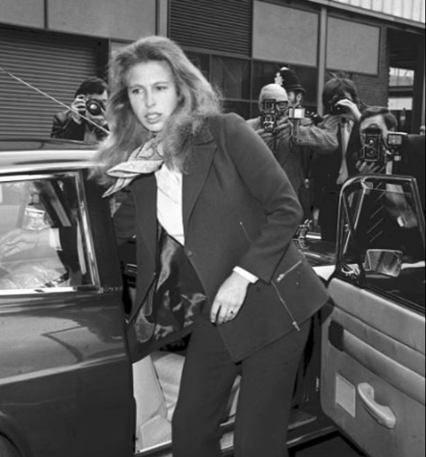 Princess Anne getting into a car, surrounded by photographers.