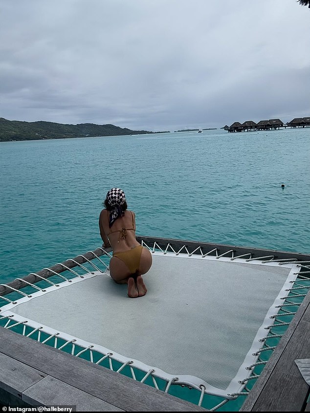 In this image she looks out at the horizon while on a netted platform