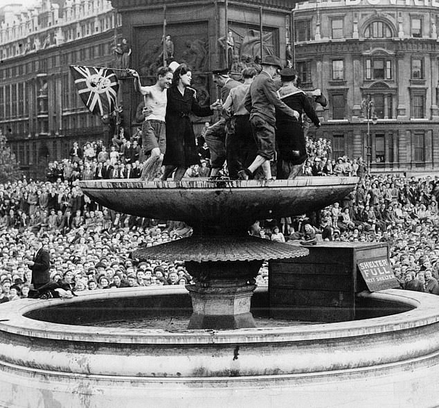 Londoners celebrate VJ Day in Trafalgar Square, August 15, 1945. Some naughty men and women climbed onto the fountain
