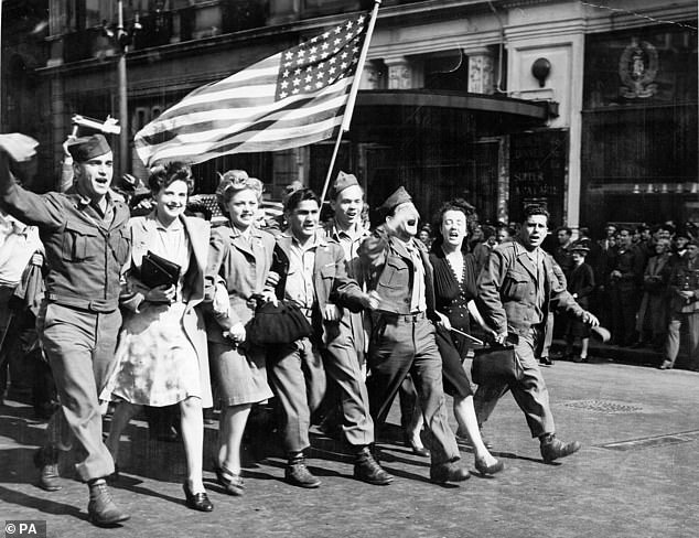 American soldiers parade the 'Stars and Stripes' through Piccadilly Circus, London, during VJ Day celebrations