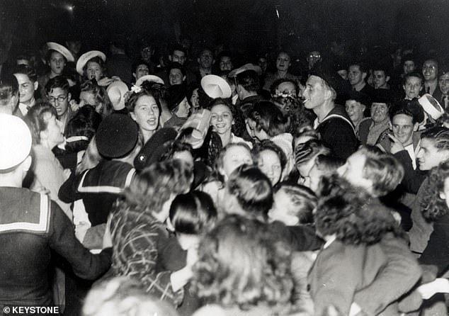 Crowds dancing and singing in Piccadilly Circus after news of Japan's impending surrender emerges, August 11, 1945