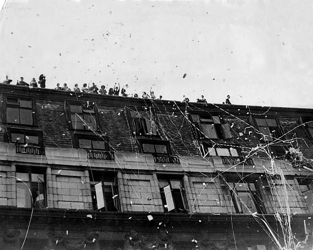 Office workers on the roof of their office building in Aldwych throwing tape and paper into the street below during VJ Day celebrations, August 10, 1945