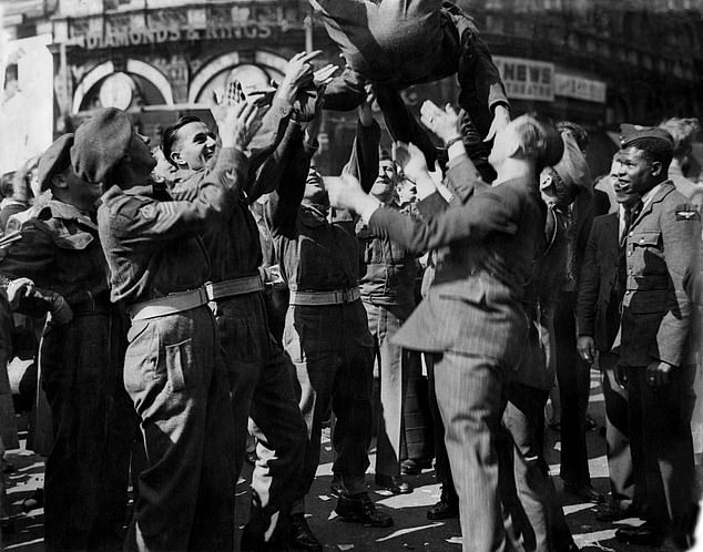 Soldiers throw a comrade into the air at Piccadilly Circus as they celebrate VJ Day, August 10, 1945