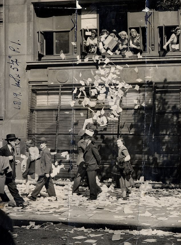 Workers at the Air Ministry letting loose a shower of papers from their office window after they heard news of Japan's surrender, August 10, 1945