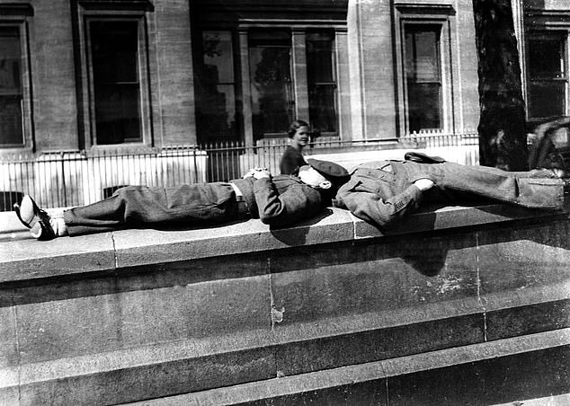 Two soldiers lie down with their caps over their eyes, the VJ Day celebrations seemingly passing them by, August 16, 1945
