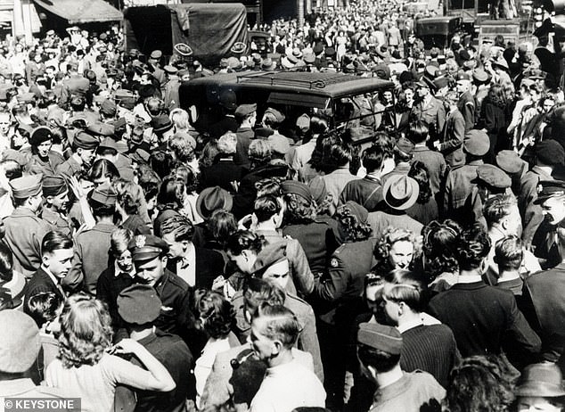 A crowd in Piccadilly stopping the traffic as they celebrate the end of the war, August 11, 1945