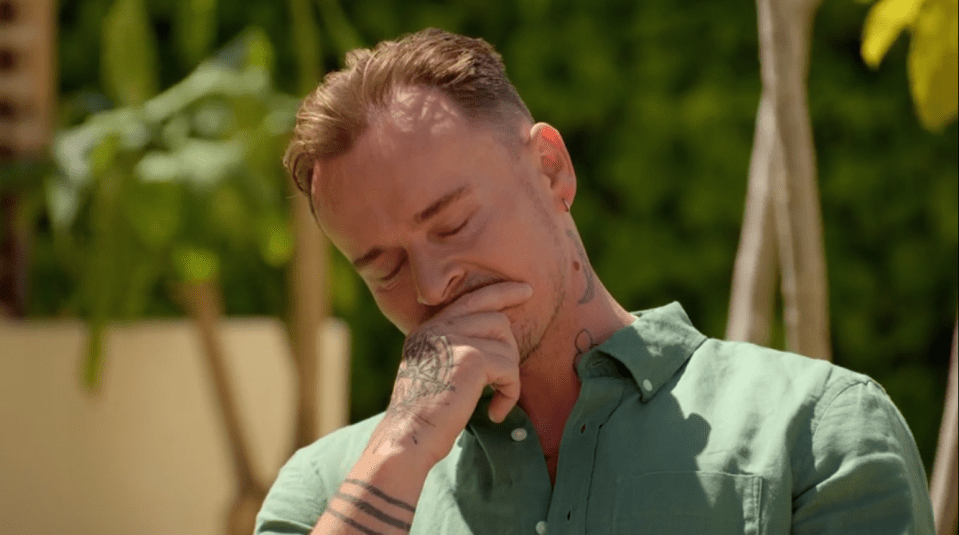 Man crying with his hand to his face.