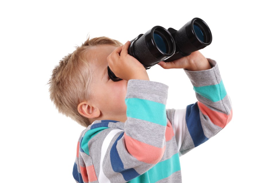 Young boy looking through binoculars.