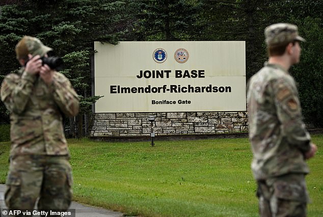 Members of the military stand outside an entrance to Joint Base Elmendorf-Richardson in Anchorage, Alaska