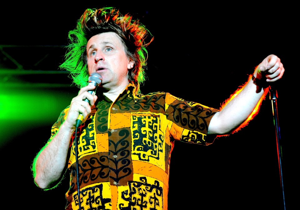 Comedian Milton Jones performing on stage.