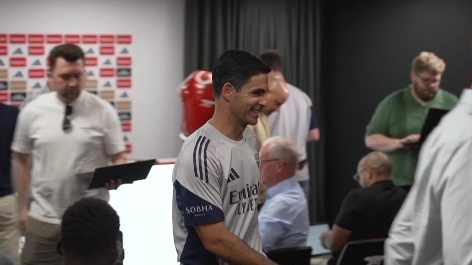 Mikel Arteta smiling in a meeting.