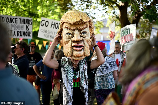 A demonstrator dons a mask of US president Donald Trump as they protest JD Vance's visit to the Cotswolds
