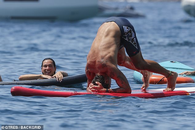 Callum flaunted his six-pack while wearing black swimming shorts as he larked around on the paddle board