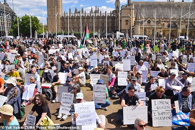 Protesters sit in Parliament Square holding placards in support of Palestine Action on August 9