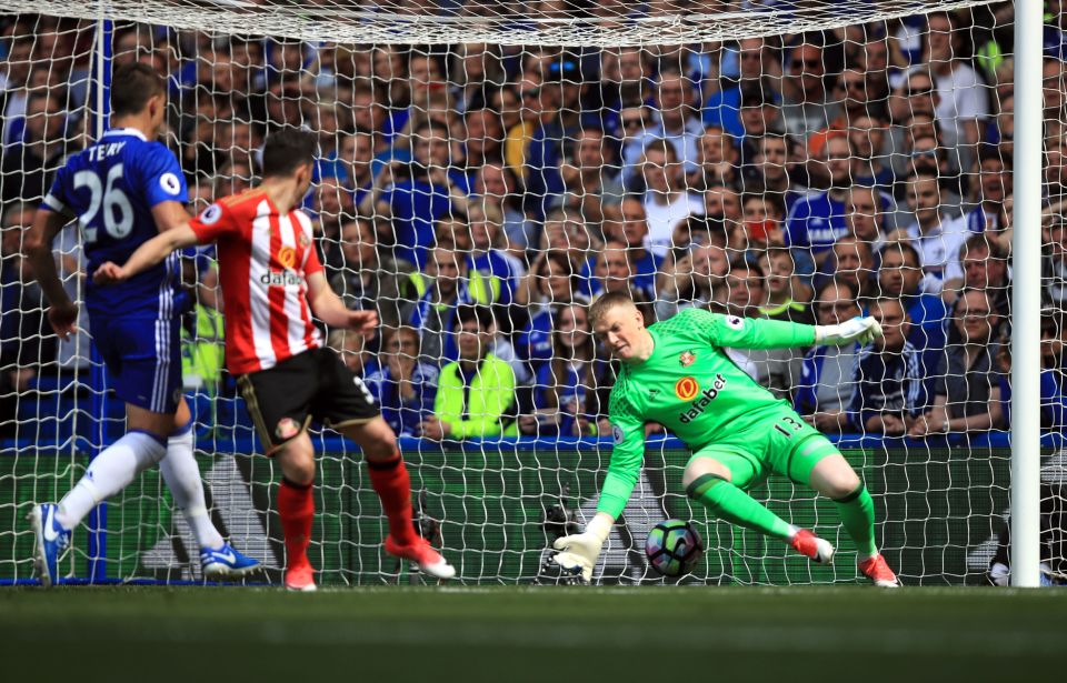 A soccer goalie dives to stop a goal.