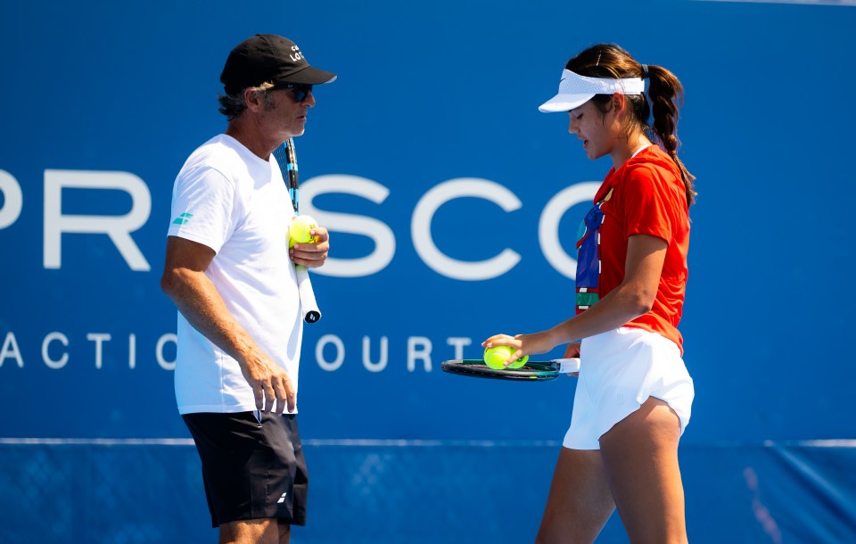 Emma Raducanu of Great Britain talking to her coach during tennis practice.