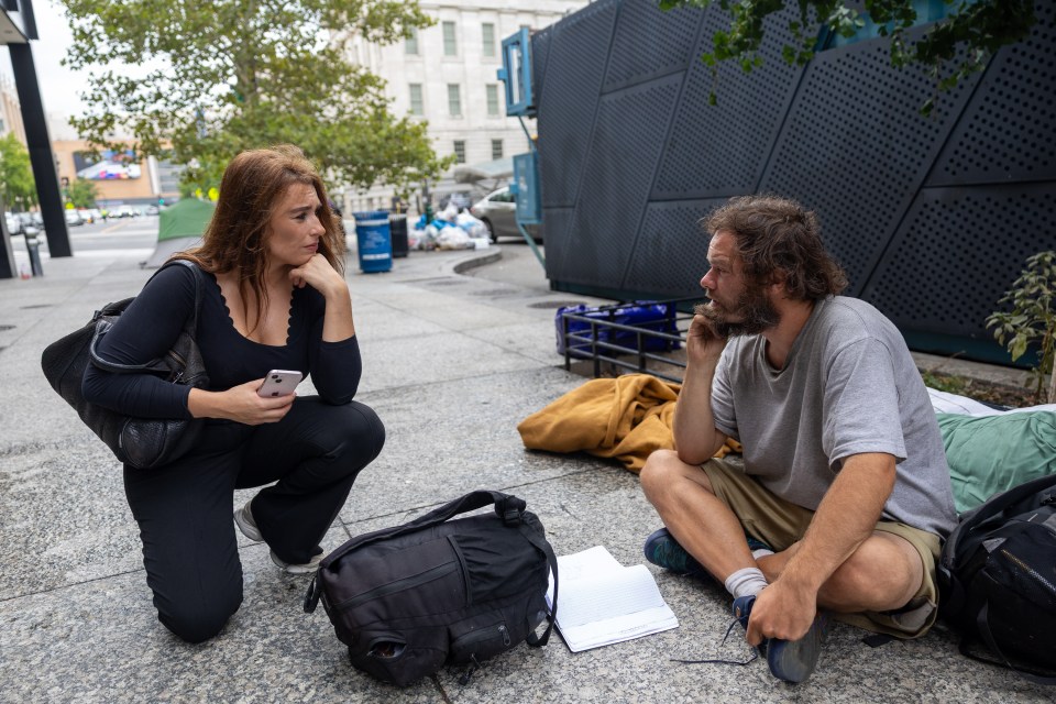 A woman speaks with a homeless man in Washington, D.C.