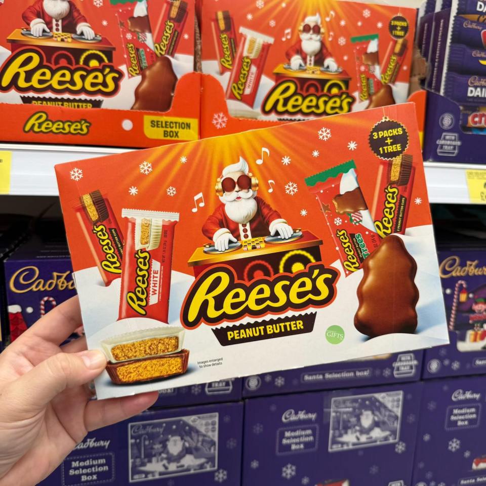 Hand holding a Reese's Peanut Butter Christmas selection box.