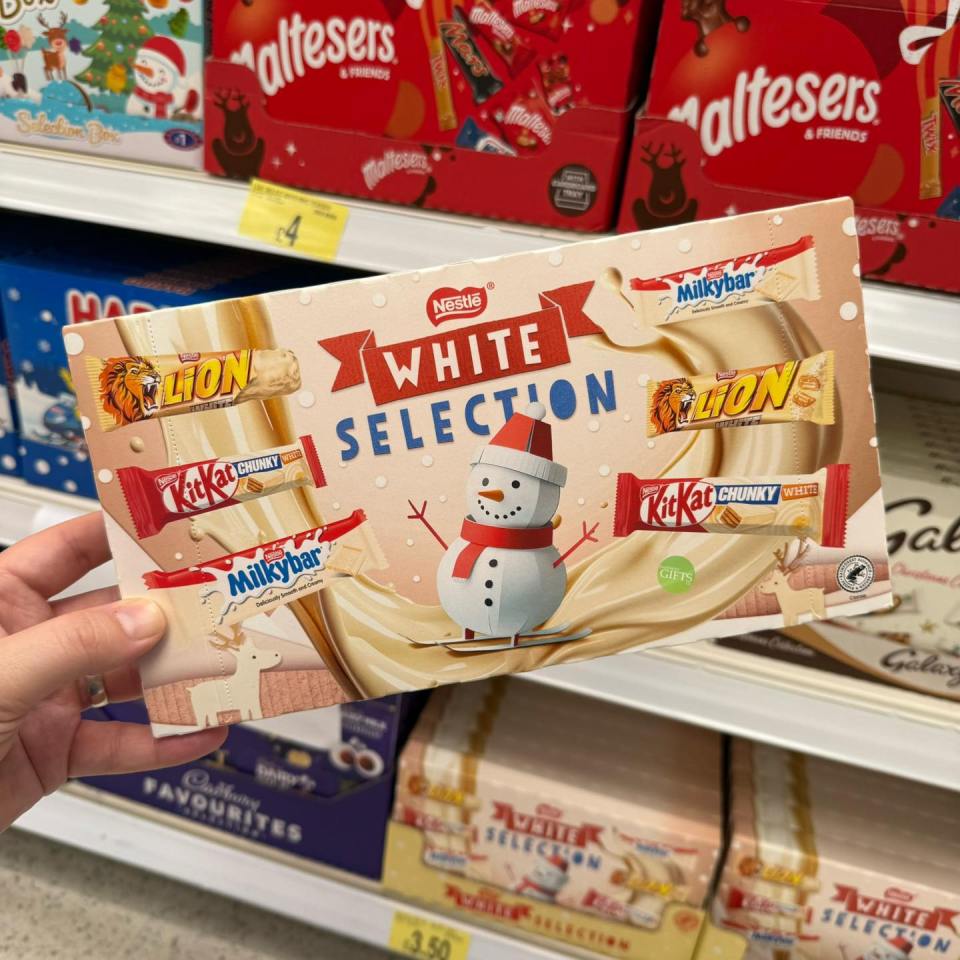 Hand holding a box of Nestlé White Selection chocolates featuring KitKat, Milkybar, and Lion bars.