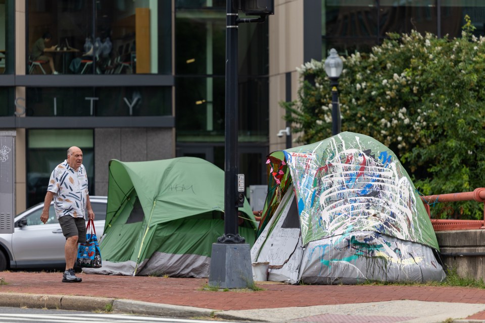Man walking past homeless encampment in Washington, D.C.