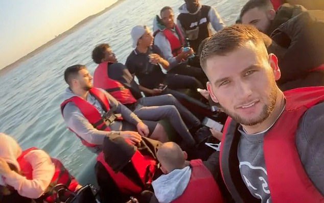 An Albanian man sharing a selfie showing him with other migrants on a packed boat in 2022