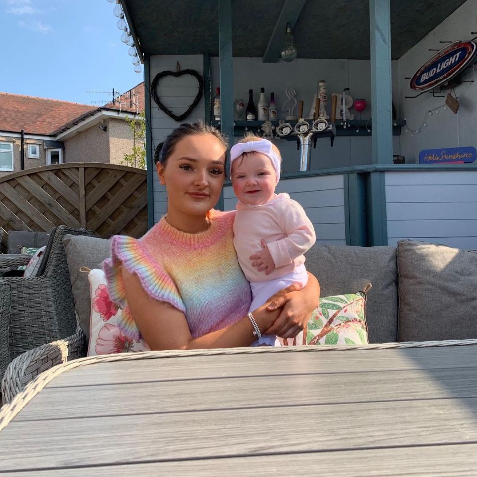 Millie Radford holding baby Ophelia in the garden.