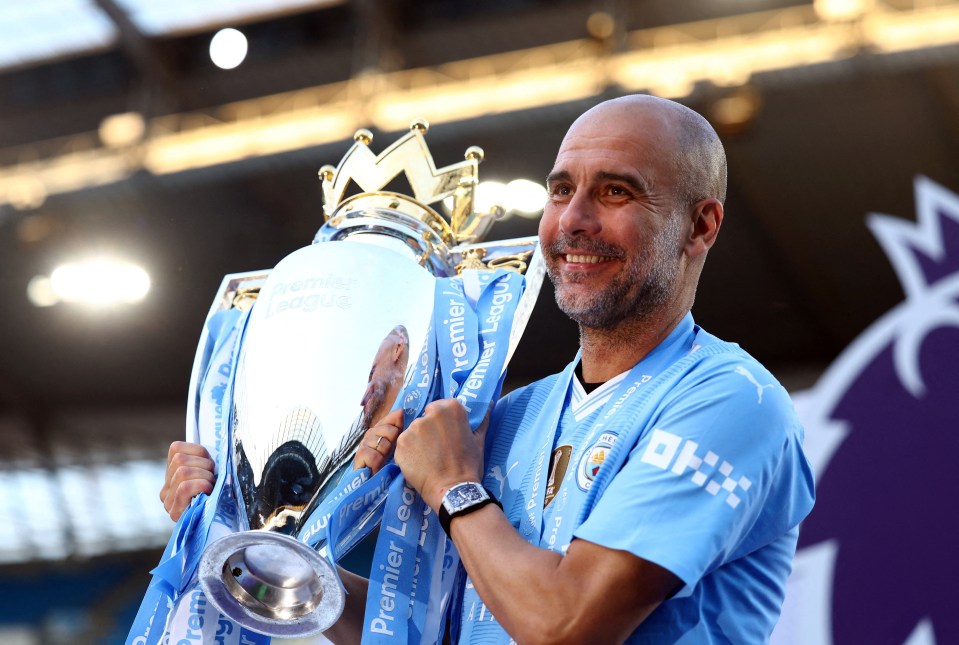 Pep Guardiola holding the Premier League trophy.