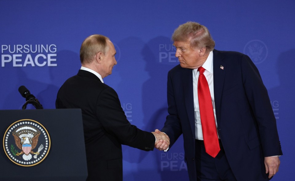 Trump and Putin shaking hands at a press conference.