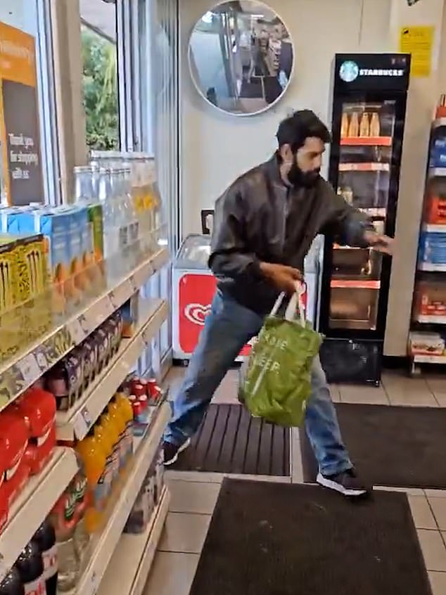 Dramatic footage (pictured) filmed by an onlooker shows the man swiping what appears to be family bags of chocolates from the shelves to fill up a Waitrose carrier bag