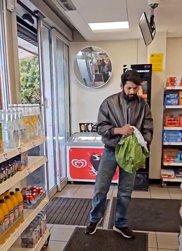 The dark-haired, bearded man (pictured) looks completely unassuming upon first entering the quiet store, in a green bomber jacket, jeans and sports trainers