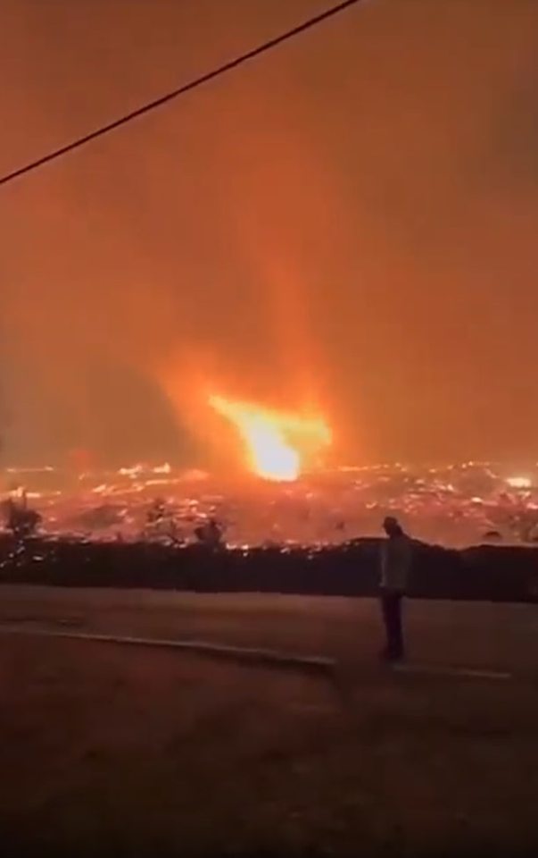 Person watching a large fire.
