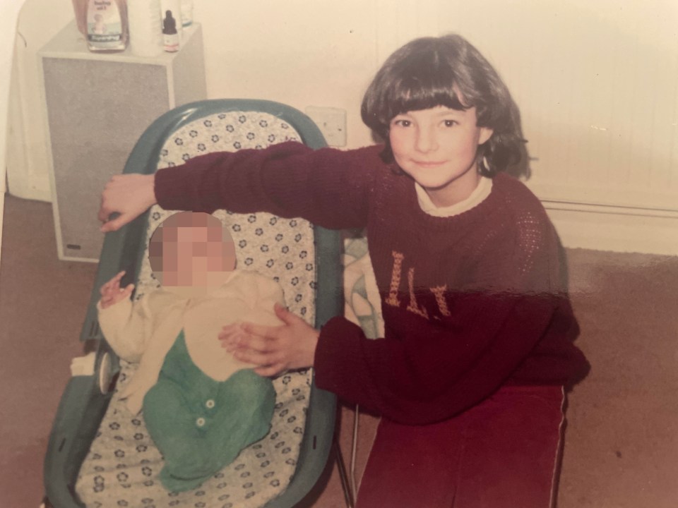 Photo of a young girl with a baby in a bouncy chair.