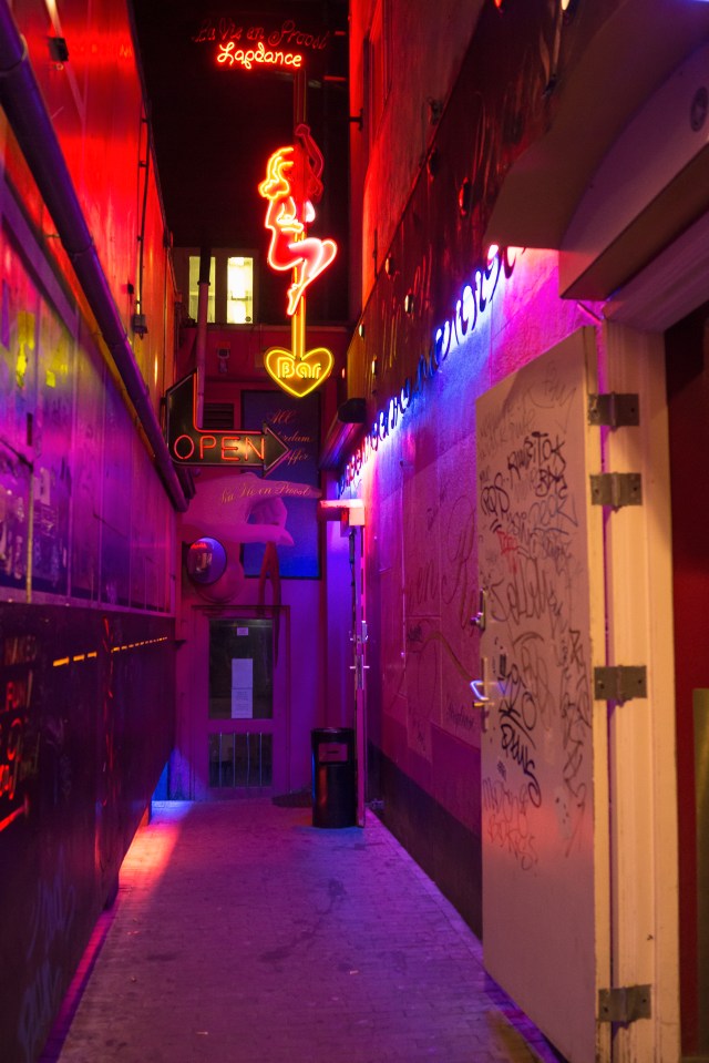 a neon sign for fragrance hangs above a doorway