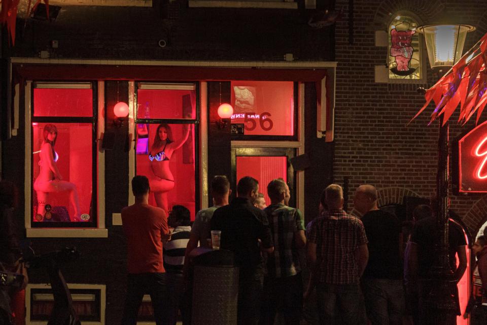 Men watching prostitutes in a window in Amsterdam's Red Light District.