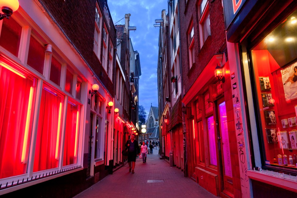 a narrow alleyway with a sign that says ' amsterdam ' on it