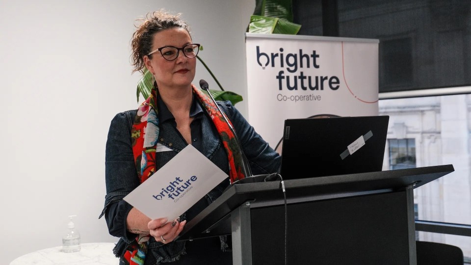 Woman speaking at a podium at a Bright Future Co-operative event.