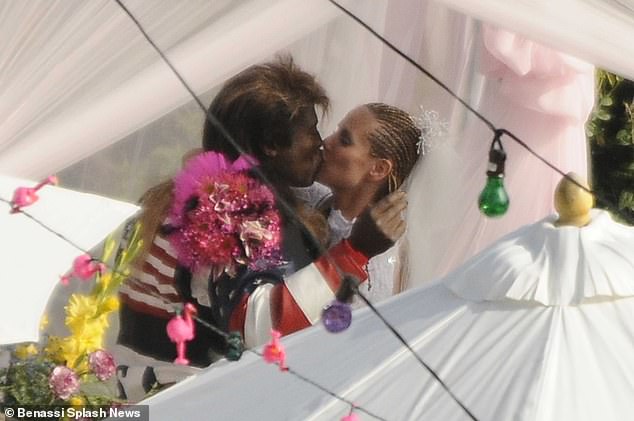 One of the vow renewal themes was dubbed 'white trash' - Klum wore a white lace jumpsuit with braided hair while Seal opted for a leather jacket with an American flag painted over it and a mullet wig