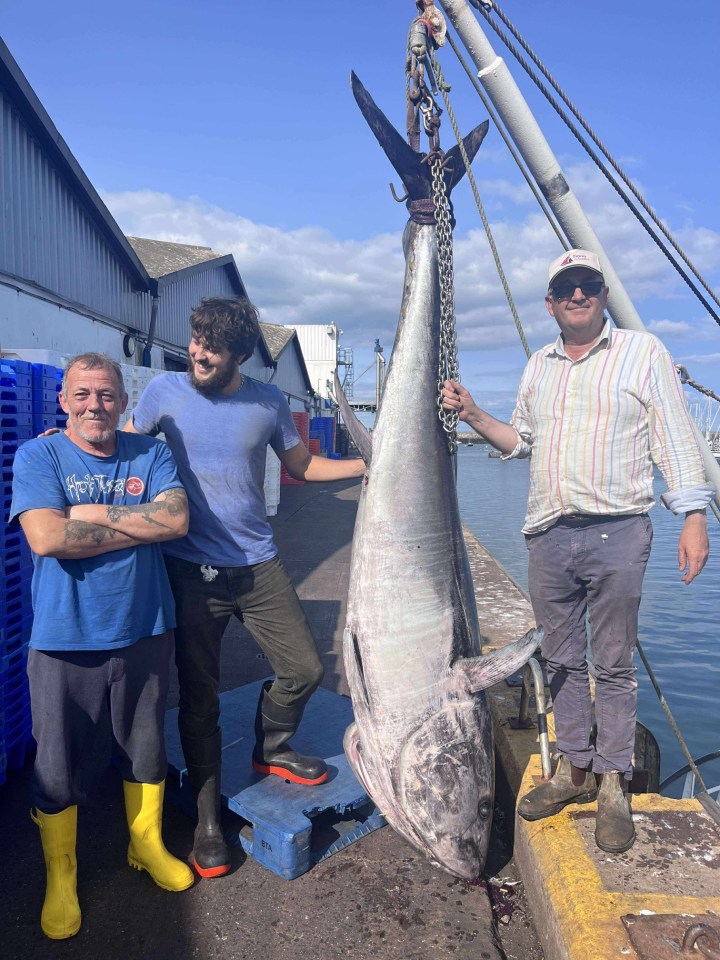 Father and son with a large tuna they caught.