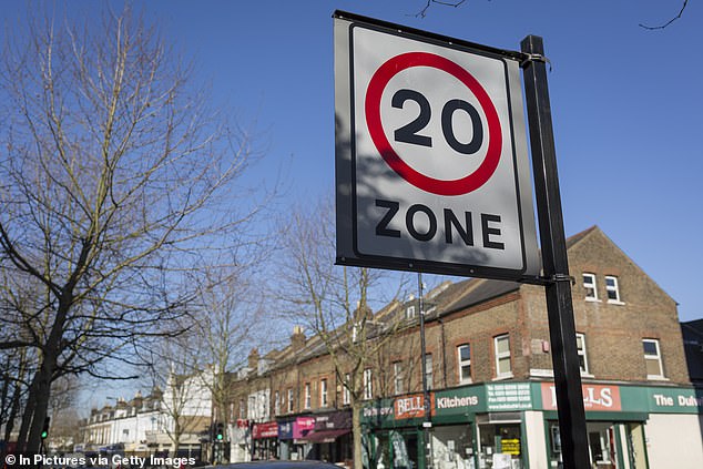 A 20mph speed limit signpost and local shops on Lordship Lane, in East Dulwich, London