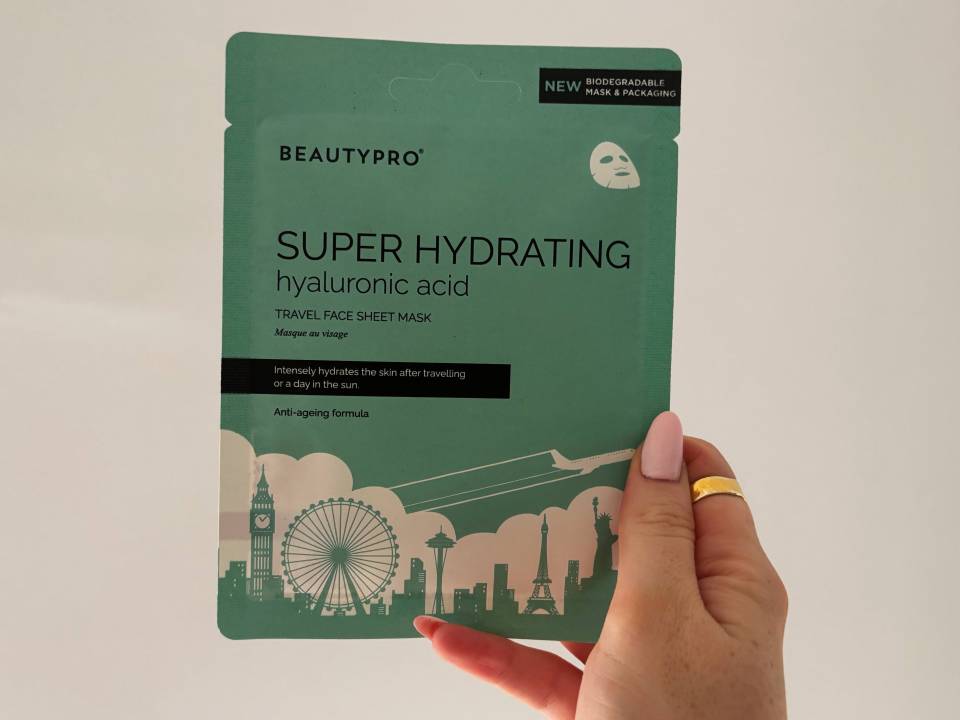 Hand holding BeautyPro Super Hydrating hyaluronic acid travel face sheet mask.