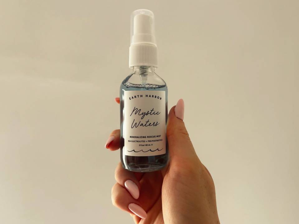 Hand holding Earth Harbor Mystic Waters Mineralizing Rescue Mist.