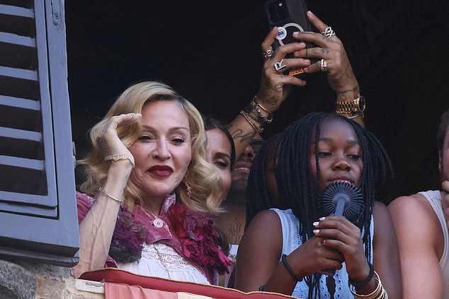 The Queen of Pop couldn't wipe the smile off her face as she watched the Italian horse race