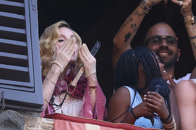Madonna blew kisses to fans as she watched from a balcony