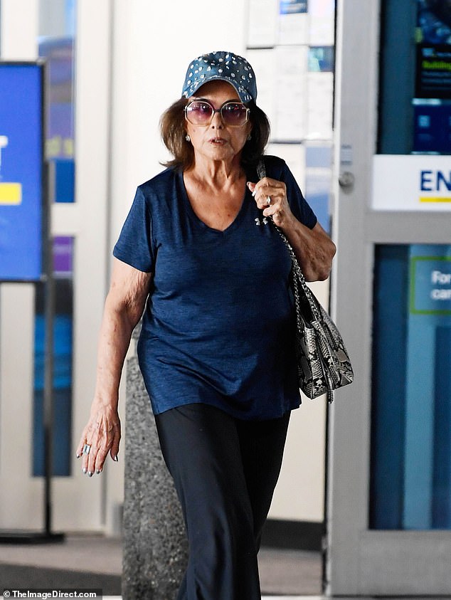 She looked equal parts comfortable and chic as she paired a dark blue T-shirt with satin, black pants and accessorized with flashy jewelry