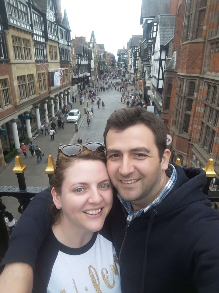 Selfie of a couple in front of a street scene.