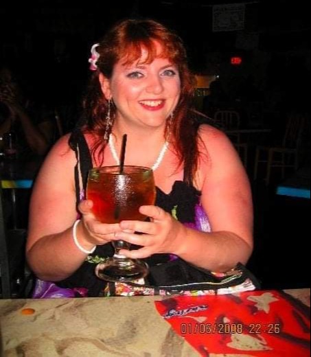 Woman holding a large drink in a bar.