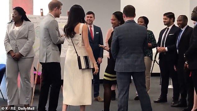 The split-second moment shows, according to the body language expert, Meghan¿s social confidence glow while Harry¿s insecurities rise closer to the surface